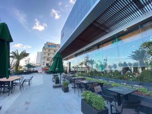 a patio with tables and chairs and a building at Wise Stay Scenia Bay Apartment in Nha Trang