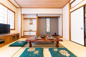 a living room with a table and a tv at 大吉屋2号館 ワンフロア貸切部屋 名駅離れ in Nagoya