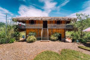 a large wooden house with a thatch roof at Hello Mu Cang Chai Homestay in Mù Cang Chải