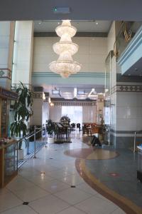 a lobby with chandeliers and tables in a building at Spark Residence Hotel in Sharjah +61 photos