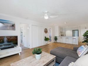 uma sala de estar com um sofá e uma televisão de ecrã plano em Peurto Vallerta Unit 2 em Gold Coast