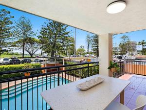uma varanda com uma mesa e vista para uma piscina em Peurto Vallerta Unit 2 em Gold Coast