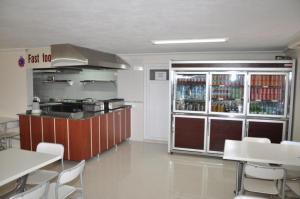 a restaurant with a kitchen with a bar and tables and chairs at Oz Ulutas Apart Pansiyon in Finike