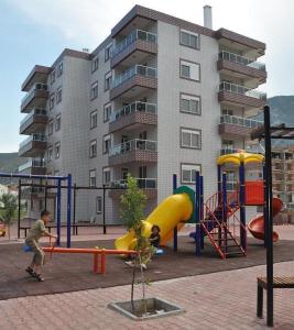 einen Spielplatz vor einem Apartmenthaus in der Unterkunft Oz Ulutas Apart Evleri in Finike