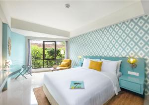 a blue and white bedroom with a bed and a window at MAMAKA Bali in Kuta