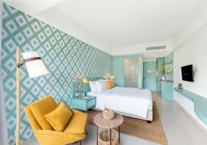 a bedroom with a bed and a chair at MAMAKA by Ovolo in Kuta