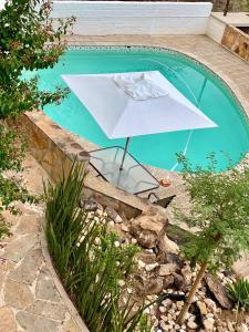 una sombrilla blanca sentada junto a una piscina en Bryan's View, en Windhoek