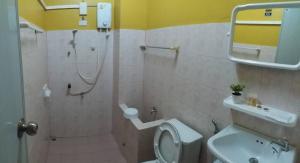 a bathroom with a shower and a toilet and a sink at GATE 14 Inn in Nakhon Phanom