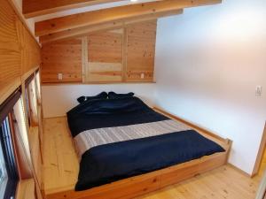 a small bedroom with a bed in a tiny house at Tombi Lodge in Iiyama