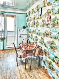 a kitchen with a table and chairs and a wall at Apartment Lukina 6 in Cheboksary