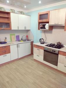 a kitchen with white cabinets and a stove top oven at Apartment Lukina 6 in Cheboksary