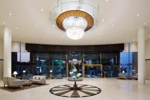 un vestíbulo con una lámpara de araña y una mesa con flores en Crowne Plaza Riyadh Palace, an IHG Hotel, en Riad