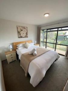 a bedroom with a large bed and a large window at Mountain Views, Nice Spot Newly renovated in Lake Tekapo