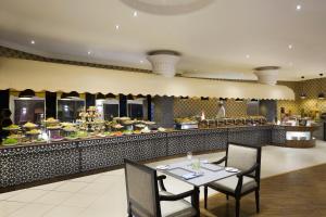 a restaurant with a table and chairs in front of a buffet at Crowne Plaza Riyadh Palace, an IHG Hotel in Riyadh