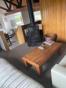 a living room with a wooden coffee table and a wood stove at Mountain Views, Nice Spot Newly renovated in Lake Tekapo