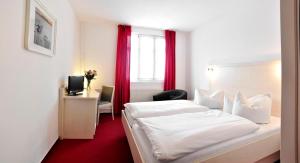um quarto de hotel com uma cama e uma janela em Apart Hotel Ferdinand Berlin em Berlim