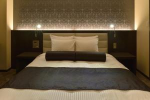 a bedroom with a large bed with a black headboard at ANA Crowne Plaza Matsuyama, an IHG Hotel in Matsuyama