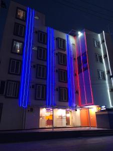 a building is lit up with blue and red lights at Sky Loft near Kempegowda International Airport in Muthugadahalli