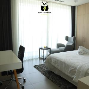 Pokój hotelowy z łóżkiem, biurkiem i oknem w obiekcie Villa Panda - Sanctuary Ho Tram Resort w mieście Hồ Tràm