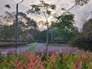 un parc avec des fleurs colorées et un étang dans l'établissement Green Two Resort, à Chanthaburi