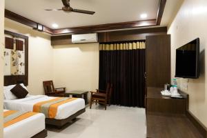a hotel room with two beds and a flat screen tv at Hotel Rituraj in Guwahati