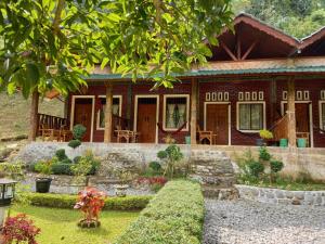 una casa con un jardín delante de ella en Sahnan Guest House, en Bukit Lawang
