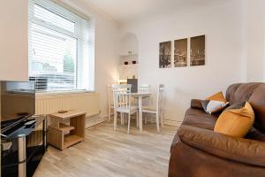 a living room with a couch and a table at Perfect Base to Stay in Swansea - TV in every Bedroom! in Swansea