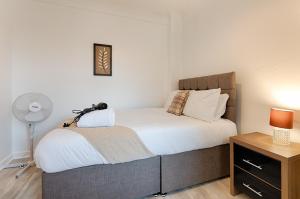 a bedroom with a bed and a desk with a lamp at Perfect Base to Stay in Swansea - TV in every Bedroom! in Swansea