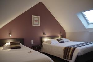 2 Betten in einem Zimmer mit Dachgeschoss in der Unterkunft Le Cadoudal in Auray