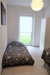 a bedroom with a bed and a window and a chandelier at family + friends apartment ferienwohnung in Ransbach-Baumbach