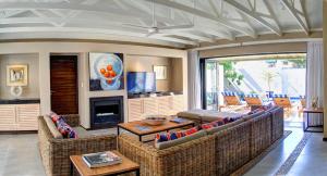 a living room with two couches and a fireplace at Scallop Lodge in Plettenberg Bay