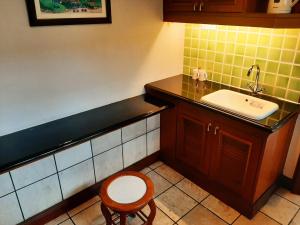 una piccola cucina con lavandino e sgabello di Wonderland Private Pool Villas at Port Dickson a Port Dickson