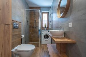 a bathroom with a toilet a sink and a bath tub at RentPlanet - Apartamenty Schroniskowa in Szklarska Poręba