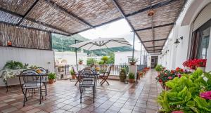 an outdoor patio with chairs and an umbrella at B&B Il Vicolo in Anacapri