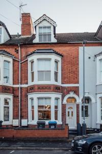 a red brick house with a white window at Beautifully Finished Spacious House! in Rugby