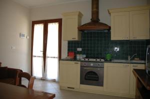 a kitchen with a stove and green tile at Case Vacanza La Dolce Vita in Saturnia
