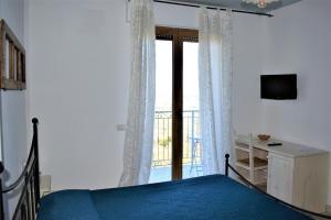 a bedroom with a bed and a sliding glass door at Casolare Azzurro in Acquaviva Picena