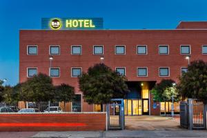 un bâtiment d'hôtel avec un panneau d'hôtel en haut dans l'établissement B&B HOTEL Madrid Arganda, à Arganda del Rey