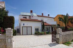 a white house with a gate and a fence at Apartment Mia in Vinkuran