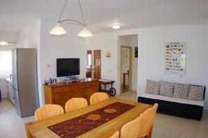 a living room with a dining table and a television at Apartment Mia in Vinkuran