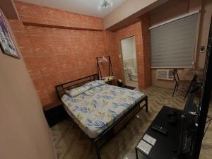 1 dormitorio con cama y pared de ladrillo en Staycation Cozy Comfortable STAY Hotel QualitY fast Internet Worldwide Channel Cable TV Gaming Netflix Sanitize, en Manila