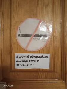 a sign on a wooden door with a no smoking sign at Тимур in Khuzhir