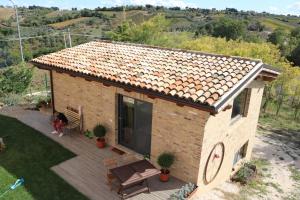 a woman sitting on a deck in front of a house at Il Melograno House in Pollutri