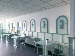 ein Esszimmer mit Tischen, Stühlen und Fenstern in der Unterkunft Fletcher Hotel - Restaurant Nieuwvliet Bad in Nieuwvliet-Bad