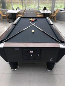 een zwarte pooltafel met een bal erop bij Fletcher Hotel - Restaurant Nieuwvliet Bad in Nieuwvliet-Bad