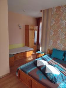 a bedroom with a bed and a bench in it at Guest House Gergevana in Velingrad