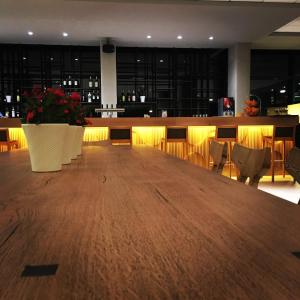 un grande tavolo in legno in una stanza con bar di Sirens Beach & Village a Mália