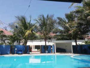 ディアニ・ビーチにあるPalm Beach Apartmentsのヤシの木が茂る家の前のスイミングプール