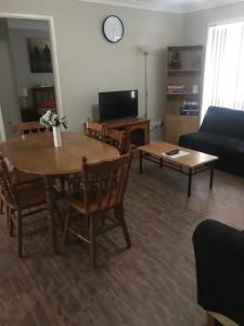uma sala de estar com uma mesa e um sofá em Grey Pebbles em Nowra