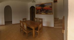 a dining room with a wooden table and chairs at Villa Sunshine in Ukunda